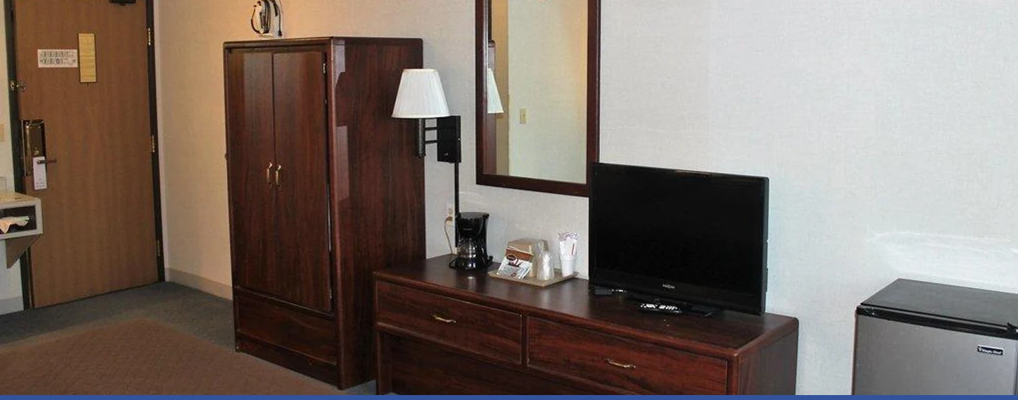 Television, refrigerator, and coffee maker in an Eastwood Inn room